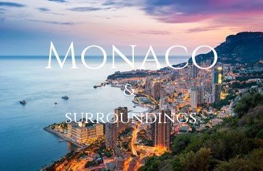 Sunset over the bay of Monaco with the buildings lit up from below and the Mediteranean sea behind the town.