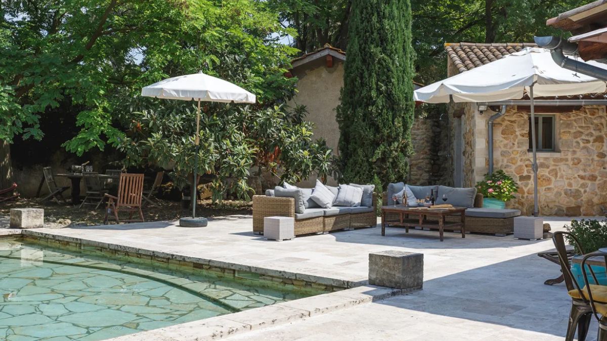 Accessible villa with view over large shallow end of the pool and charming pool house apartment in the background